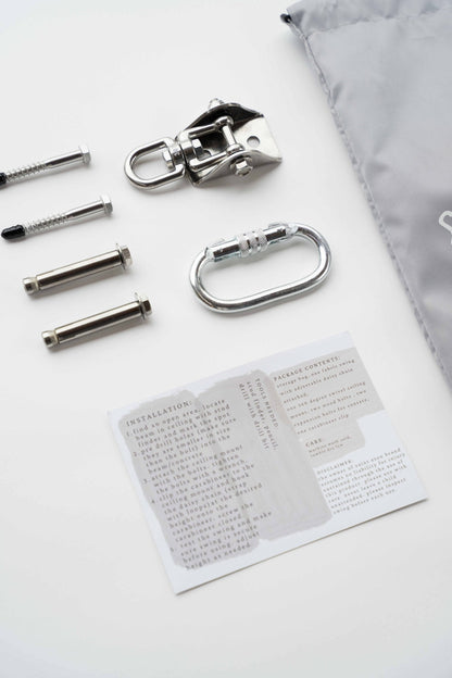 The included hardware laid out: swivel ceiling mount, locking carabiner, lag screws and expansion bolts, with the instruction card